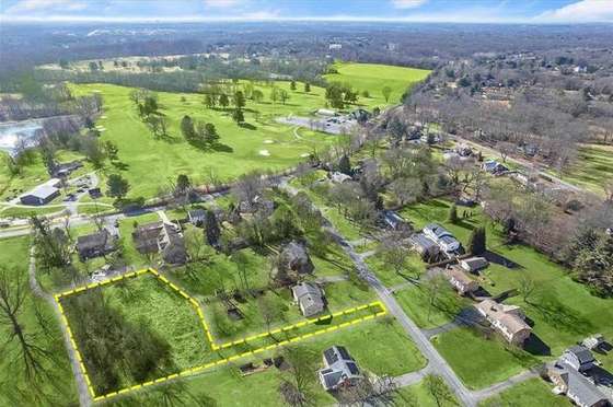 Aerial view of the same neighborhood with the target parcel boundary outlined in yellow